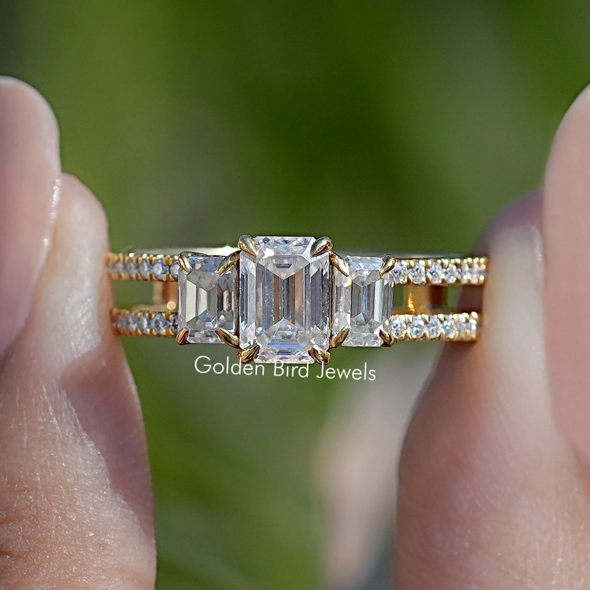 Gold-tone moissanite engagement ring with emerald-cut center stone and baguette side accents