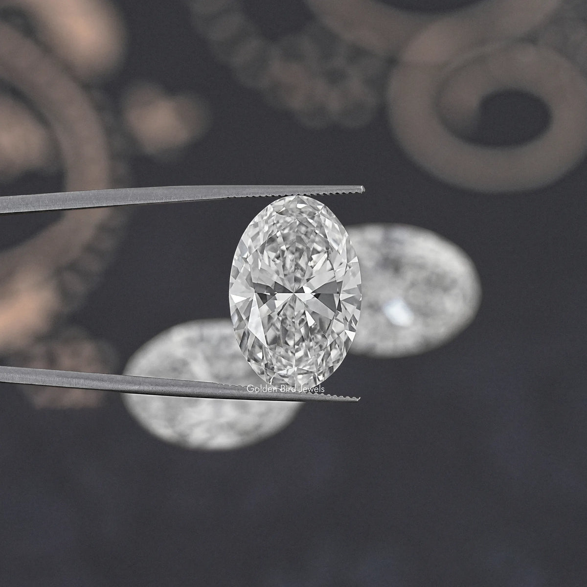 Oval-cut lab-grown diamond held between metal tweezers, clear sparkle