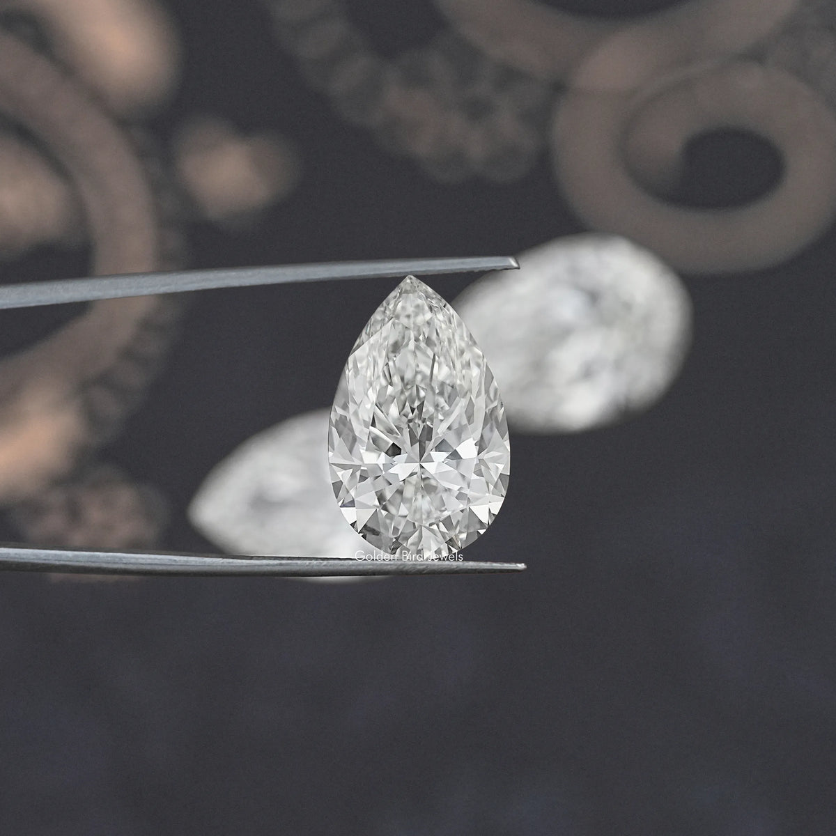 Pear-cut loose lab diamond on metal prongs, clear faceted stone