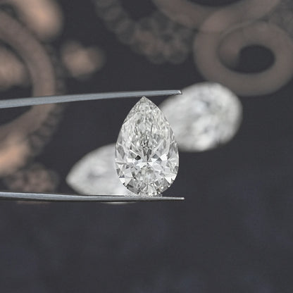 Pear-cut loose lab diamond on metal prongs, clear faceted stone