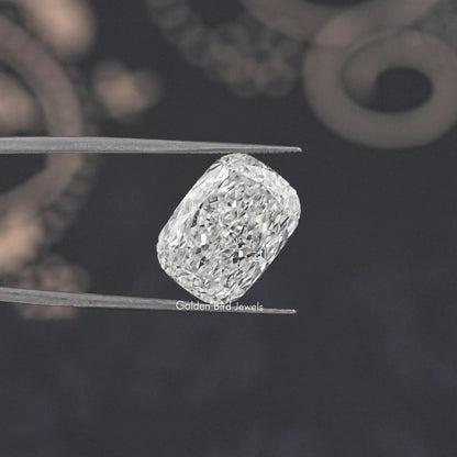Loose elongated cushion-cut diamond, clear faceted stone held in tweezers