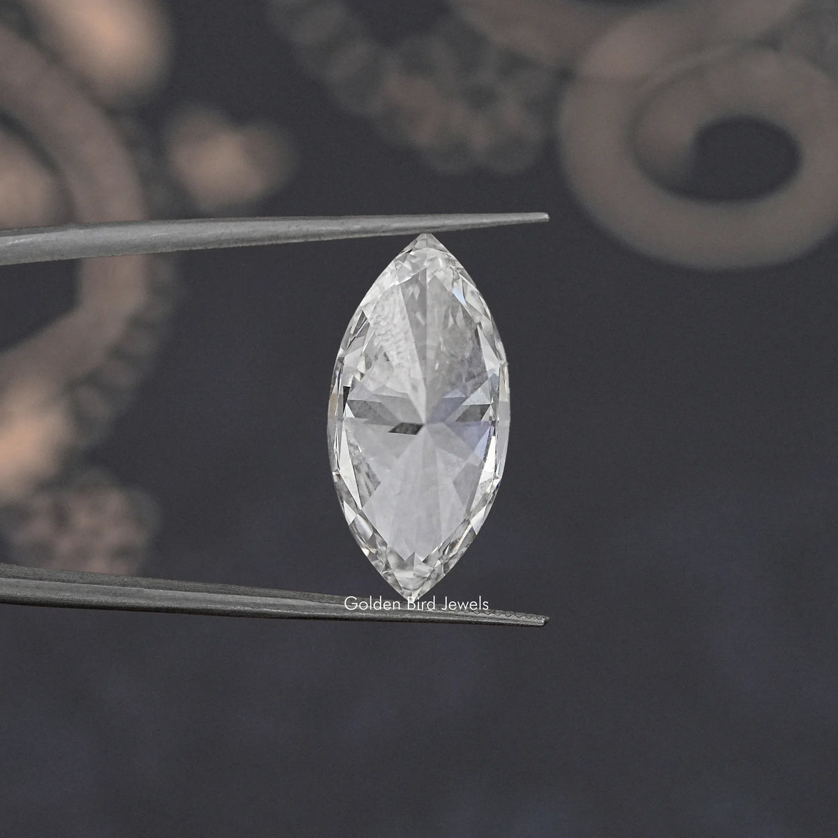 Marquise-cut loose lab-grown diamond close-up held on metal tweezers, bright white