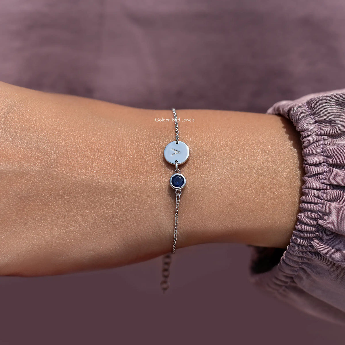 Round initial A charm bracelet with light blue disc and dark blue gemstone on chain
