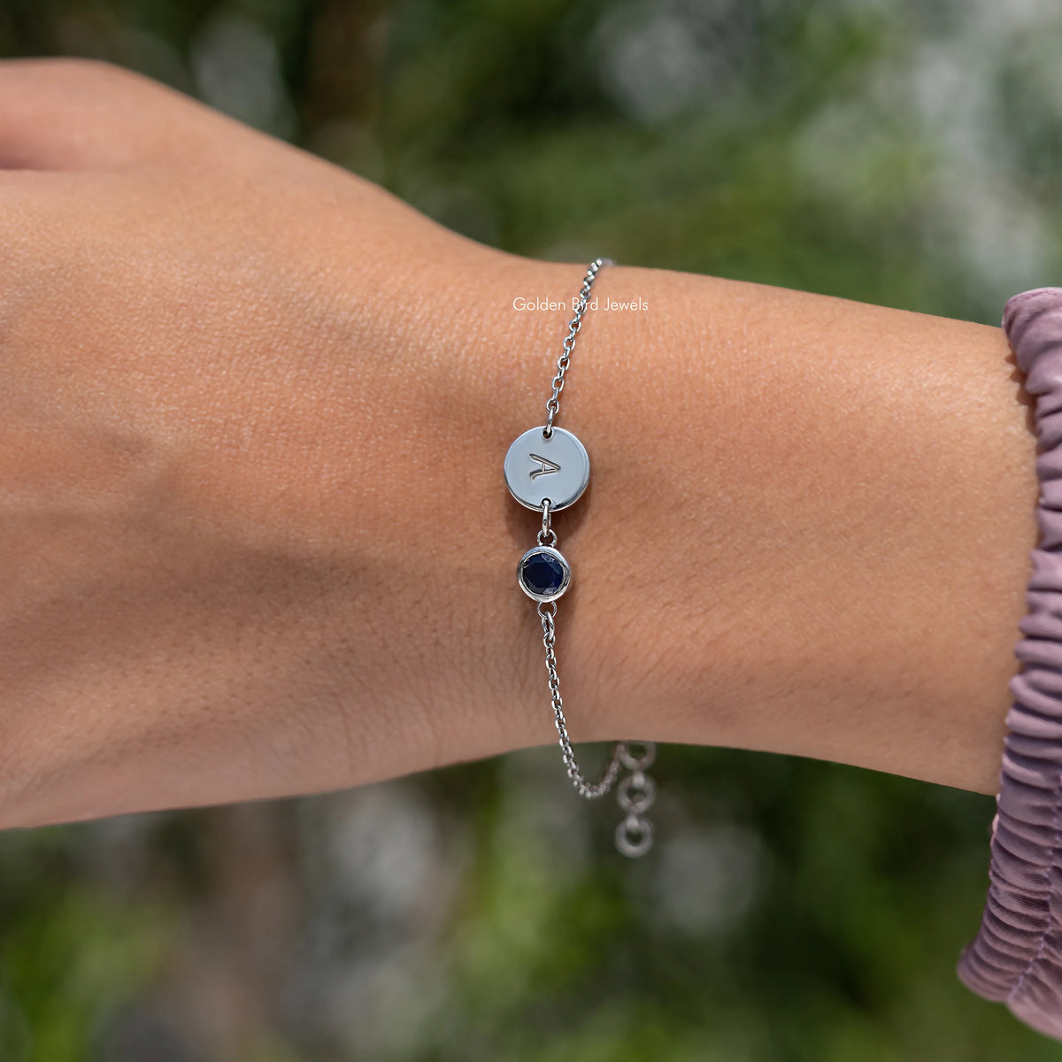 Sterling silver bracelet with round light blue initial A charm and dark blue gemstone drop