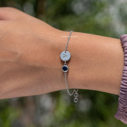 Sterling silver bracelet with round light blue initial A charm and dark blue gemstone drop