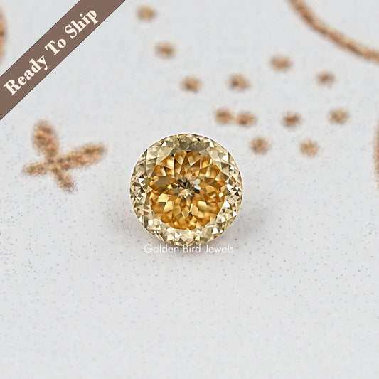 Round golden moissanite gemstone with detailed facets, front view