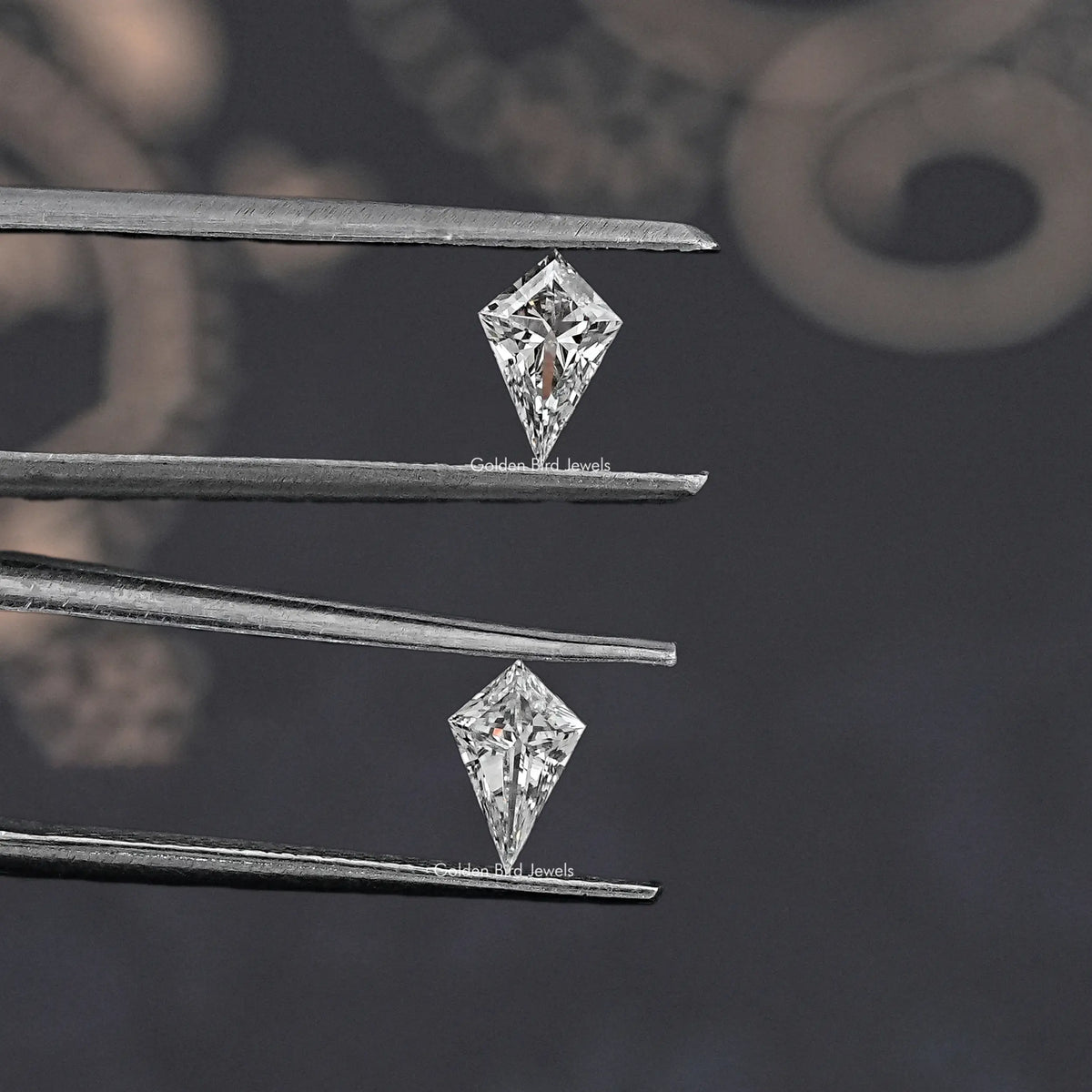 Kite-cut lab-grown diamonds held in silver tweezers, close-up