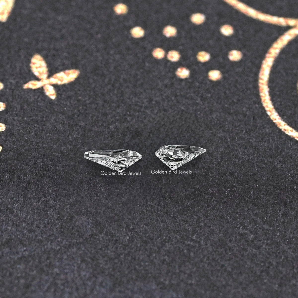 Pair of kite-cut lab-grown diamonds resting on dark jewelry display