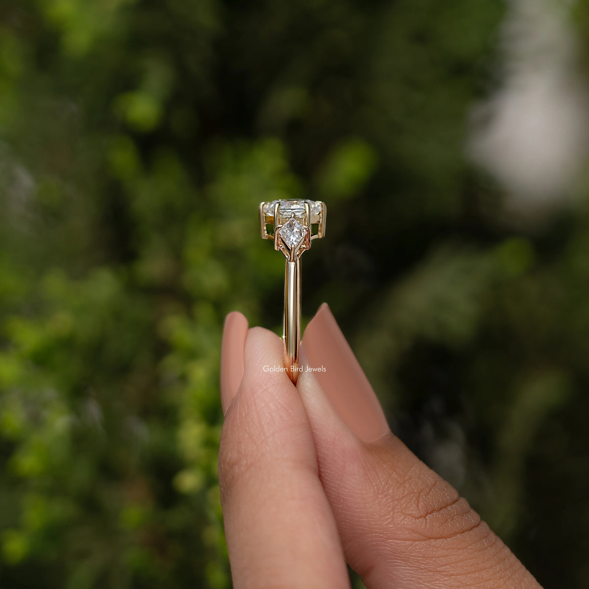 Three-stone diamond ring profile with prong-set stones, yellow gold band