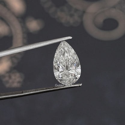 Pear-shaped lab-grown diamond in tweezers, angled close-up showing facets