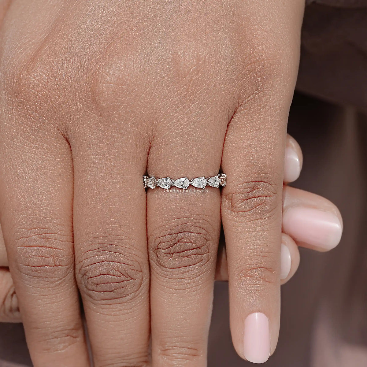 Pear-cut diamond eternity band on finger, slim silver band with continuous stones