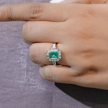 Silver halo engagement ring with emerald-green center square and geometric bezel
