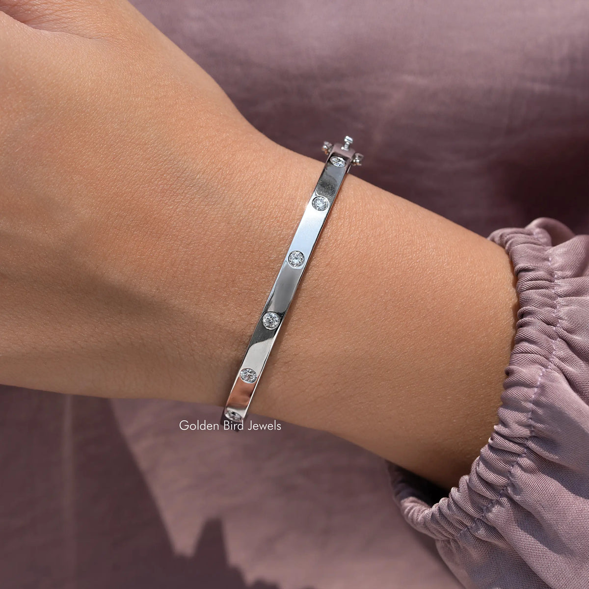 Silver flush-set lab diamond bangle on wrist, round stones in a row