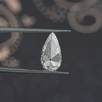 Pear-cut lab-grown diamond held in tweezers, clear white pear with crisp facets