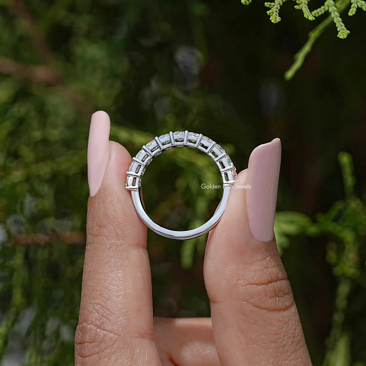 Back view of half eternity moissanite ring with row of clear round-cut stones