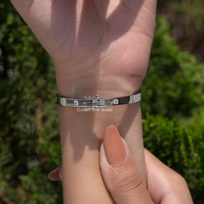 Silver flush-set lab diamond bangle on open hand, round stones across face