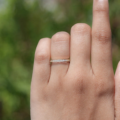 Gold-tone full eternity ring on hand, round-cut diamonds around the band