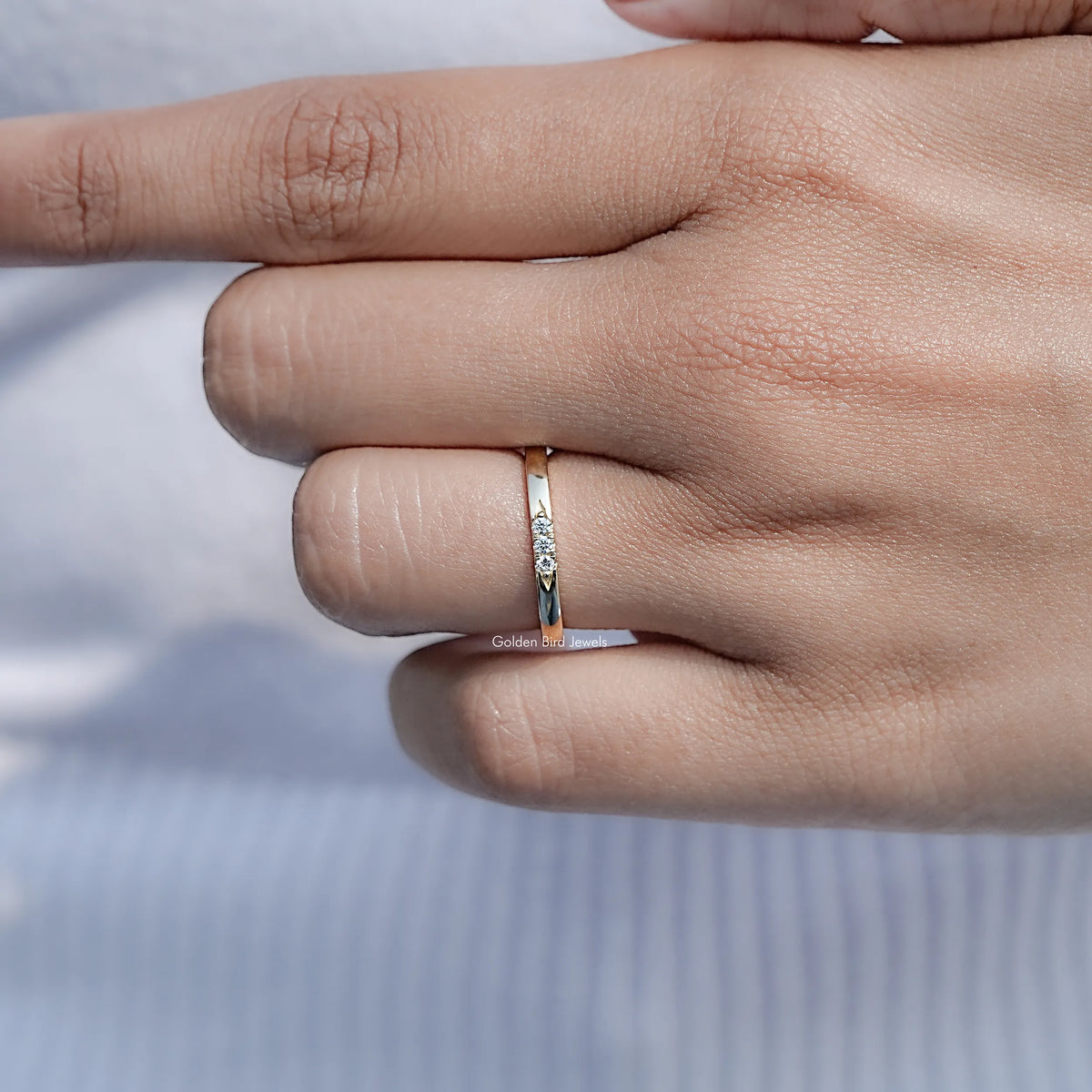 Yellow gold-tone eternity band ring with round-cut stones, close-up on hand