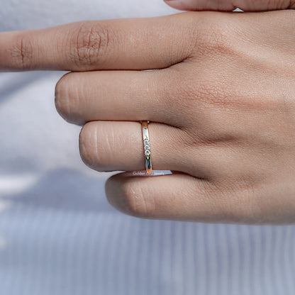 Yellow gold-tone eternity band ring with round-cut stones, close-up on hand