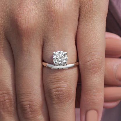 Silver solitaire ring with round lab diamond and curved band, close-up on hand