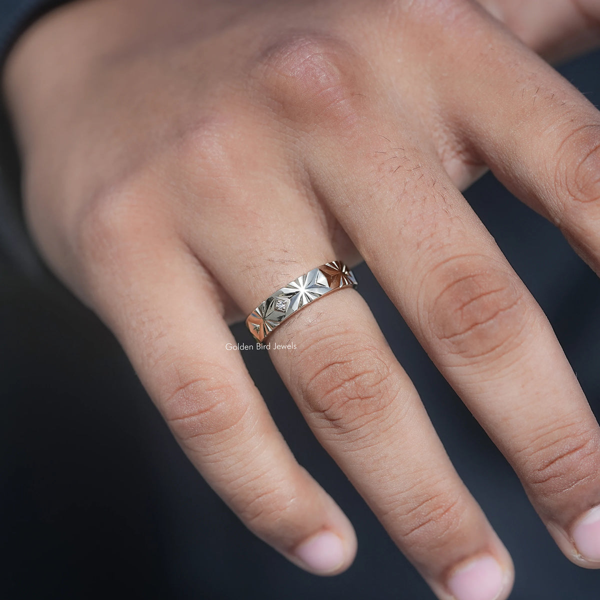 Silver men’s lab-diamond ring close-up on hand, geometric engraving and center stone