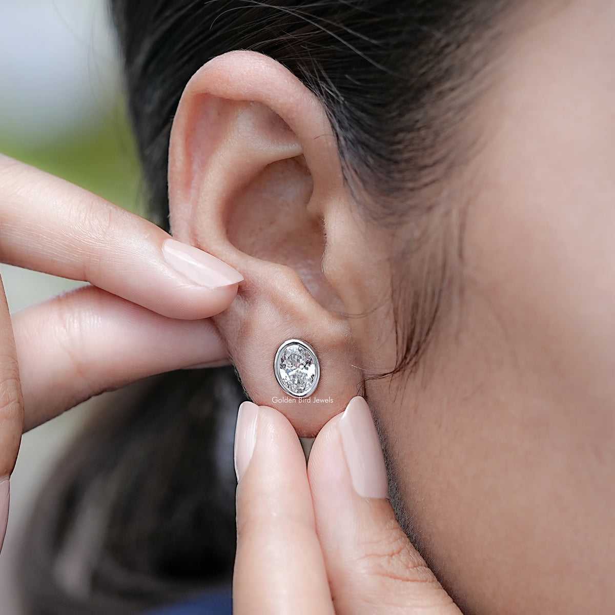 Detailed view of Bezel Set Oval Lab Diamond Stud Earrings in Ear