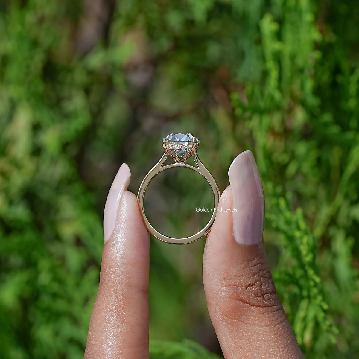 Back View of Cushion Cut Diamond Halo Engagement Ring In two fingers