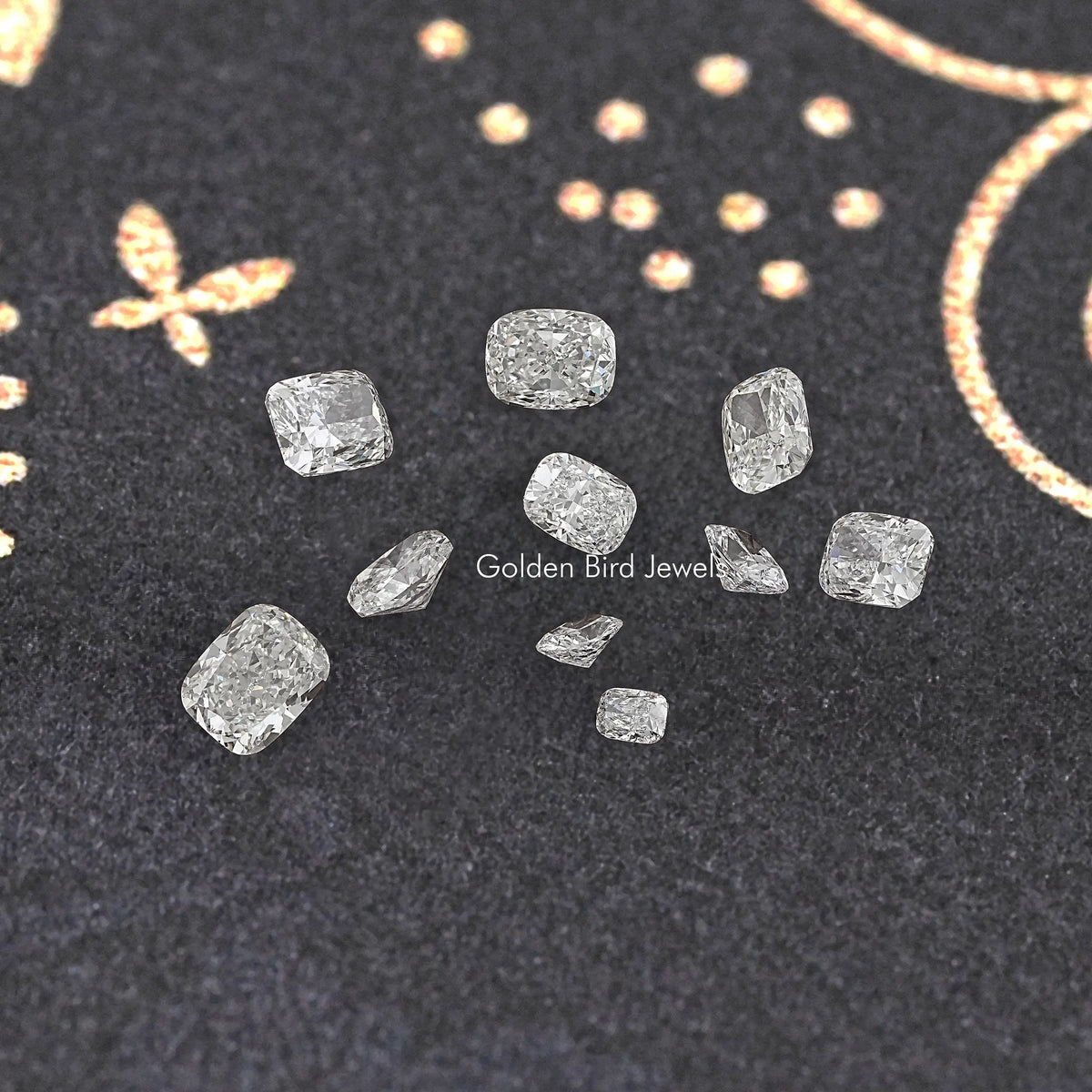 Loose lab-grown elongated cushion diamonds in assorted sizes, scattered on dark display felt.