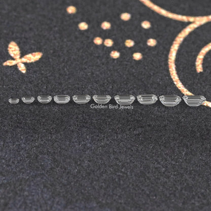 Row of loose emerald-cut lab-grown diamonds, side profile showing stepped facets