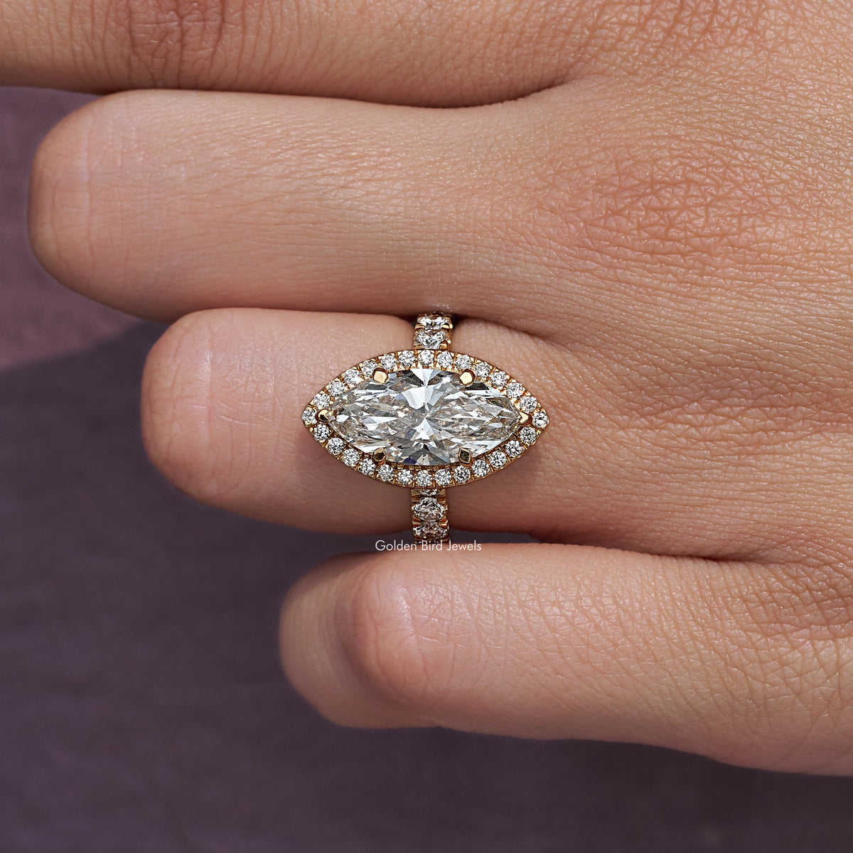 Close-up of marquise-cut diamond halo ring with sparkle prongs and side stones