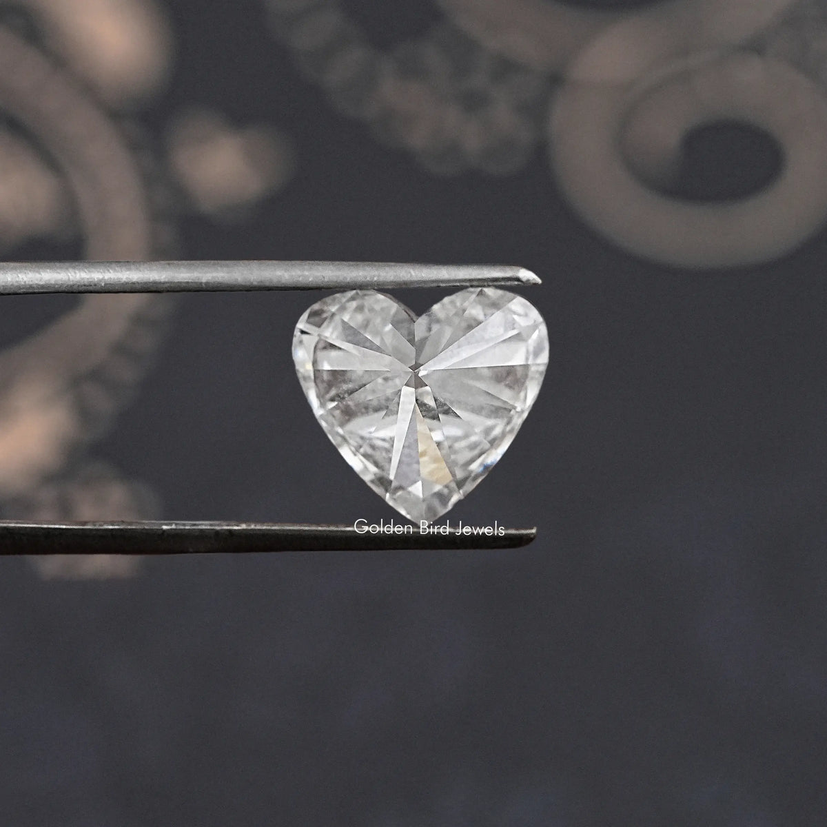 Heart-shaped lab diamond between tweezers, bright sparkle with cut facets
