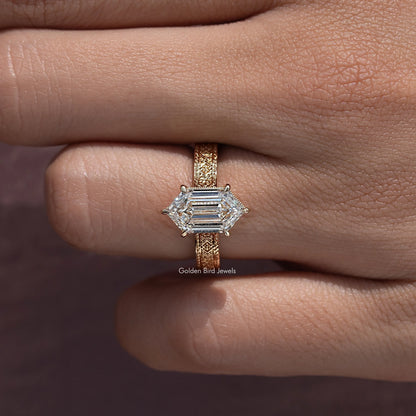 Marquise-style solitaire ring with gold-toned band, angled view of prong-set center stone