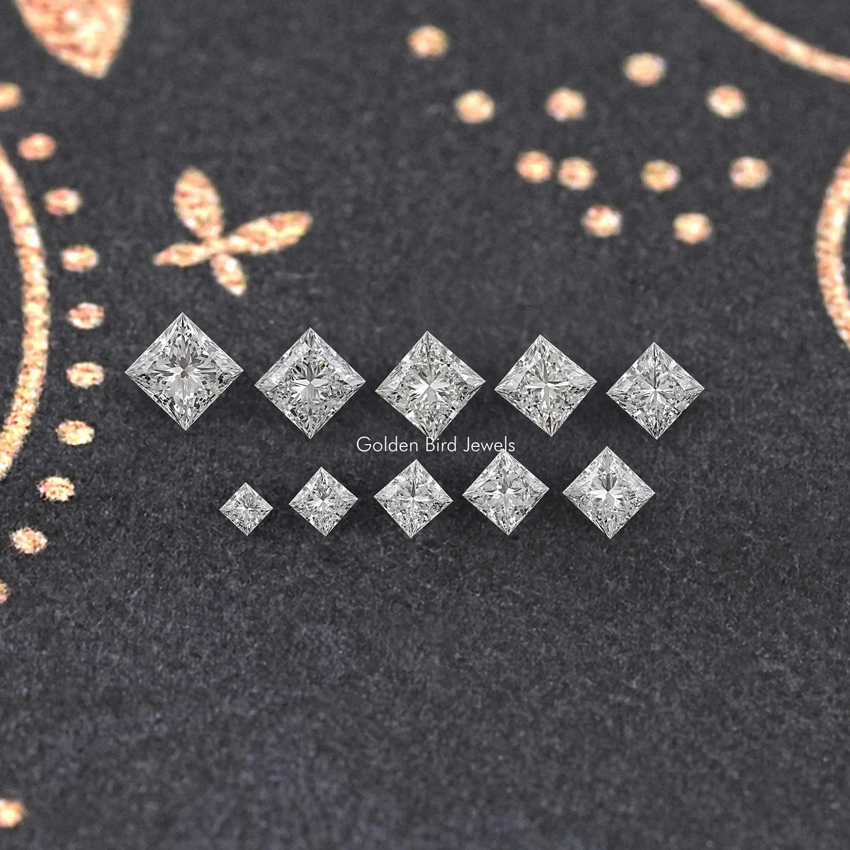 Ten princess-cut lab-grown diamonds arranged in two rows on dark felt