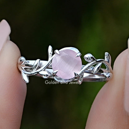 Close-up of rose quartz round gemstone leaf ring in silver