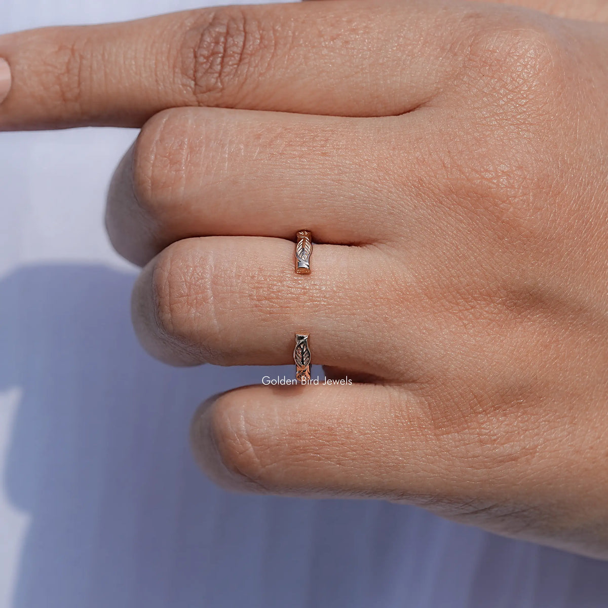 Close-up of open cuff leaf band on finger in bright daylight
