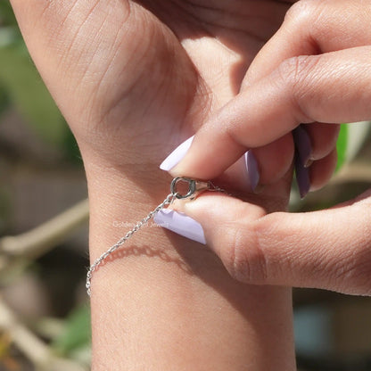 Silver tennis bracelet with emerald-cut moissanite stones and round clasp