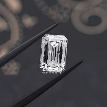 Rectangular emerald-cut lab-grown diamond held in tweezers, step facets visible
