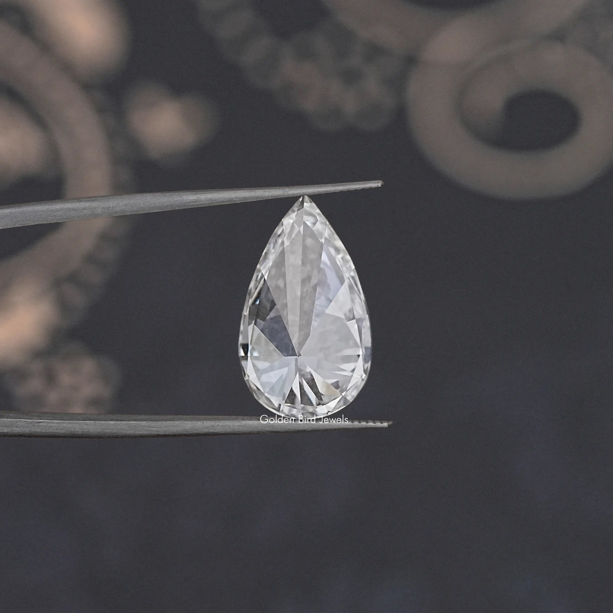 Loose pear-cut lab diamond on tweezers, clear white teardrop with facets