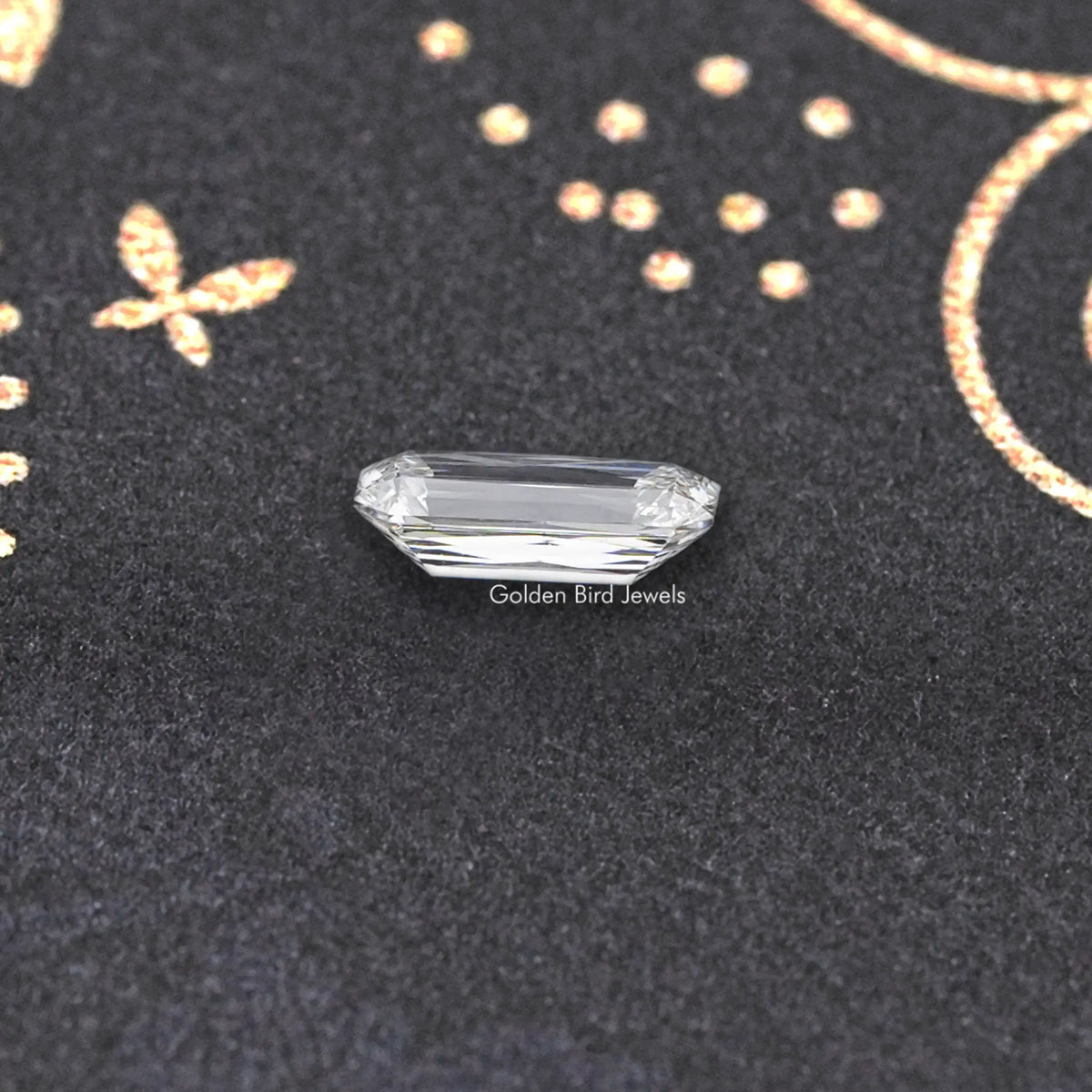 Rectangular lab-grown diamond with faceted crown, lying on dark velvet
