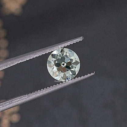 Old European round loose lab diamond in silver tweezers, angled side view