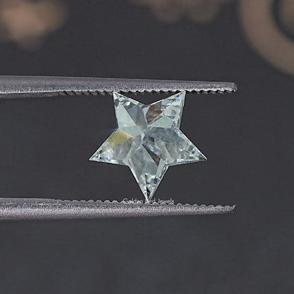 Star-cut lab diamond with clear, faceted sparkle, held between metal tweezers