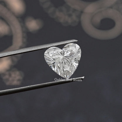 Heart lab-grown diamond held in tweezers, angled close-up with facet detail