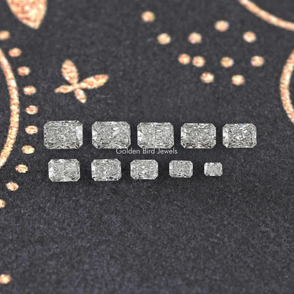 Assortment of radiant cut lab-grown diamonds, two-row layout on dark fabric