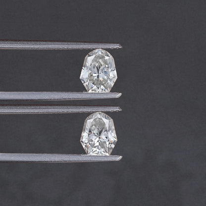 Two shield-cut moissanite stones shown with metal prongs, top and bottom