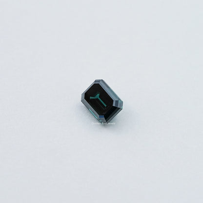 Loose emerald-cut dark green moissanite gemstone, small angled view