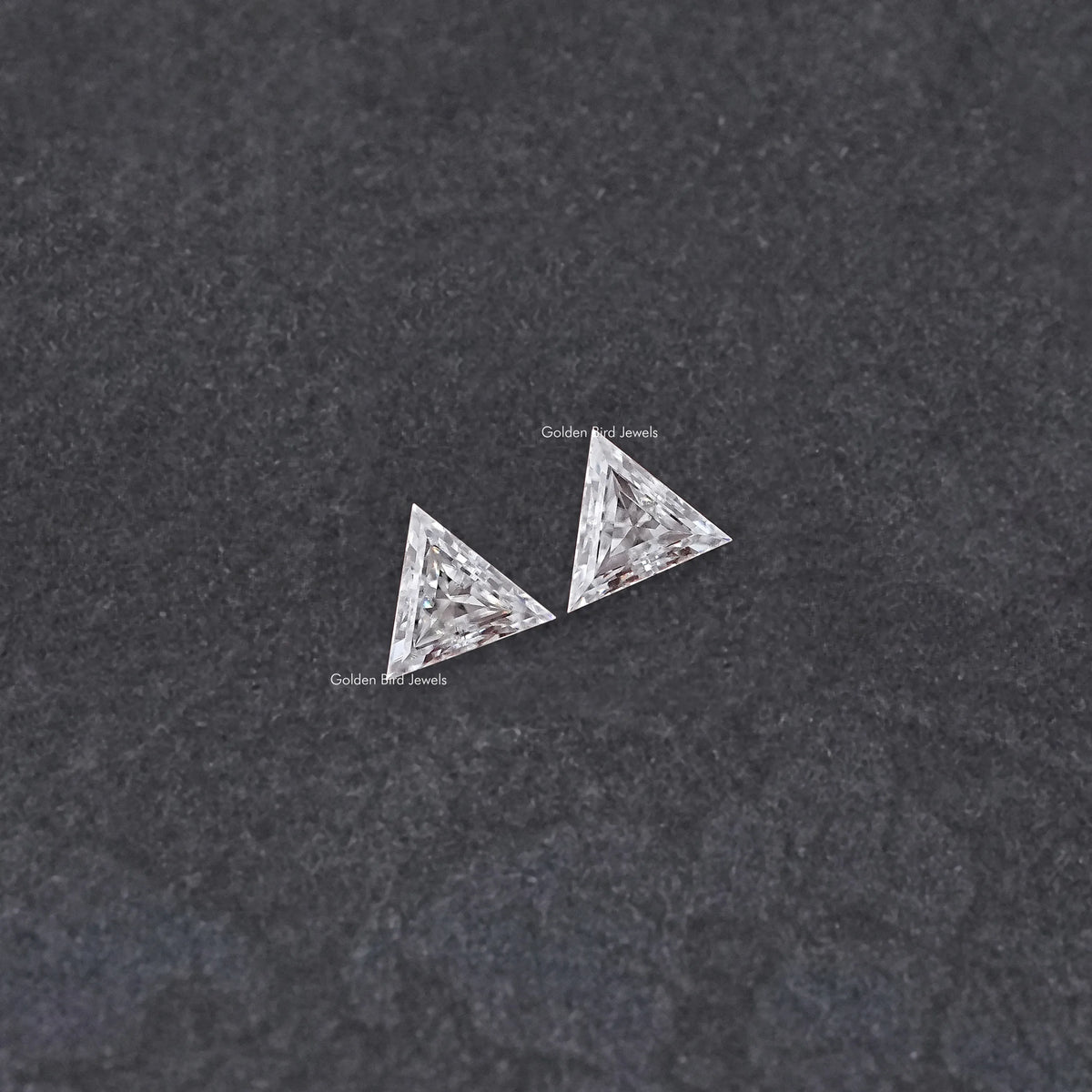 Matching triangle-cut moissanite stones, faceted angled view