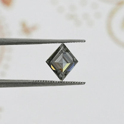 Gray moissanite lozenge shape with step facets, close-up.