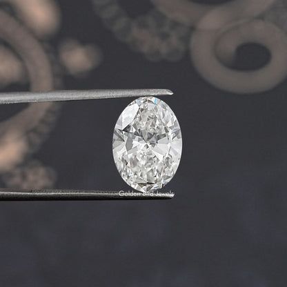 Oval-cut lab-grown diamond held by tweezers, bright facets and sparkle