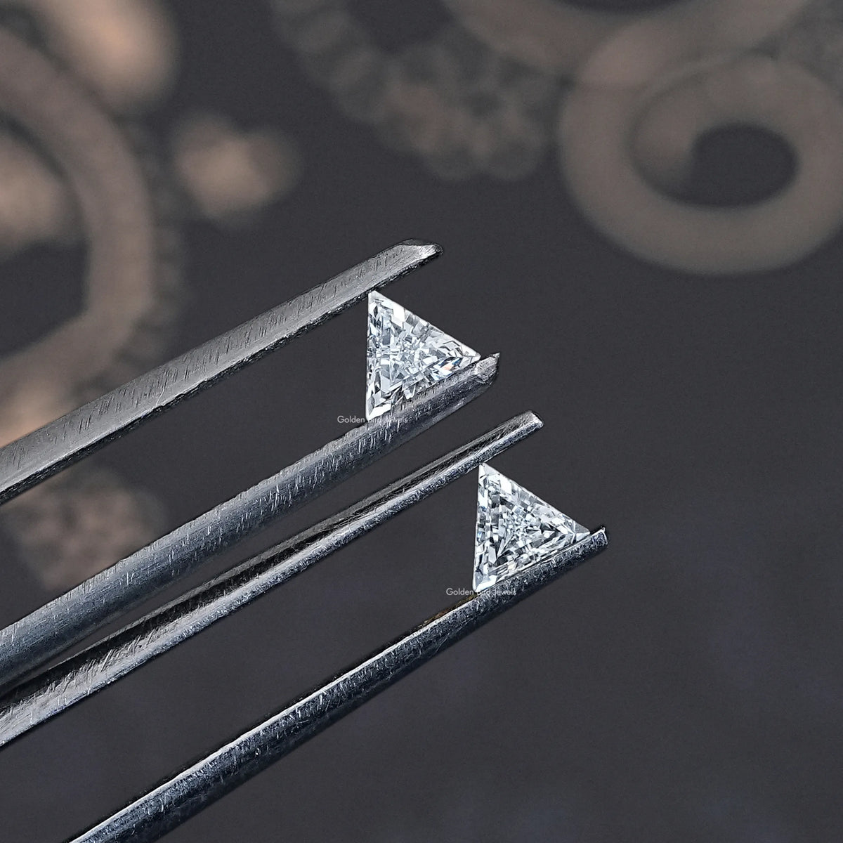 Side view of step-cut triangle lab-grown diamonds in metal prongs