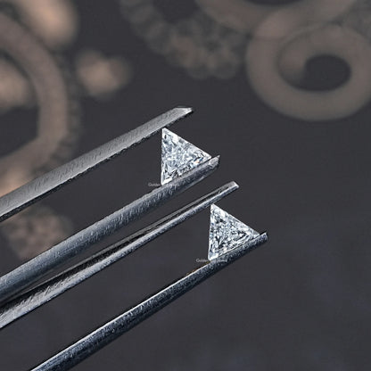Side view of step-cut triangle lab-grown diamonds in metal prongs